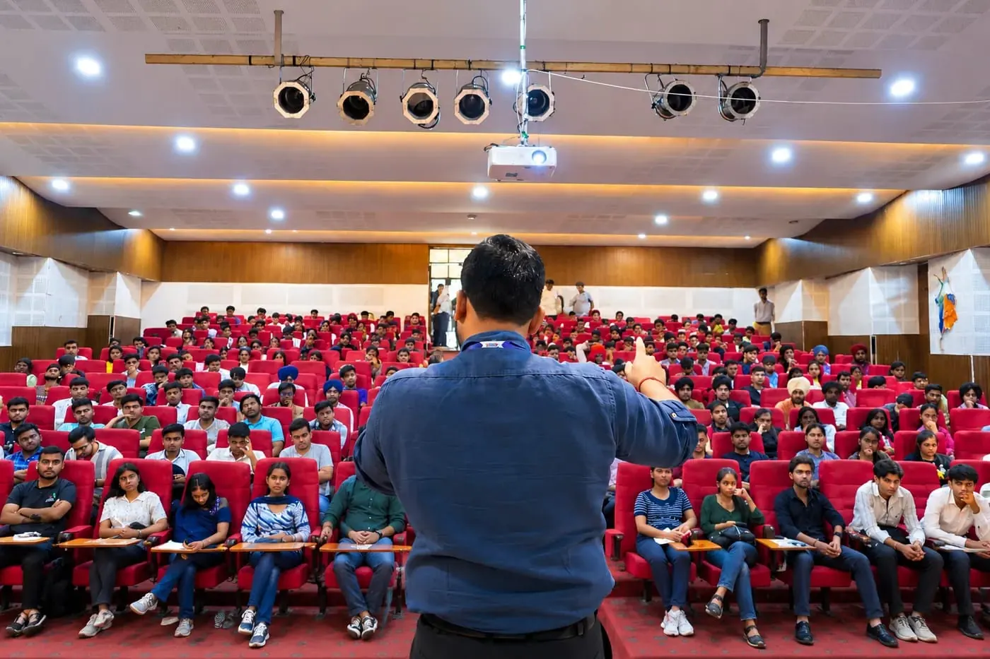 Addressing a full auditorium of students